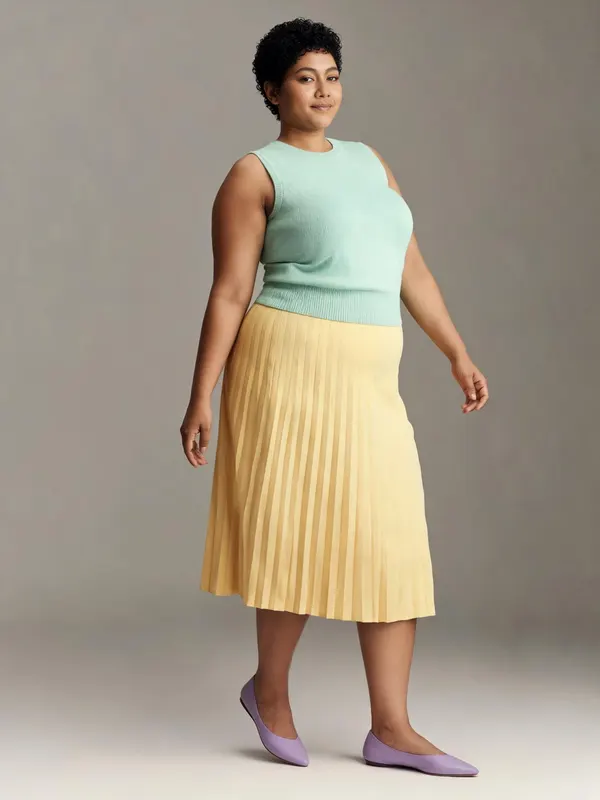 Une tenue minimaliste : débardeur menthe et jupe plissée jaune